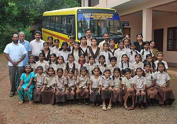 Die Mädchen des Heims für Adivasi Kinder vor ihrem Schulbus